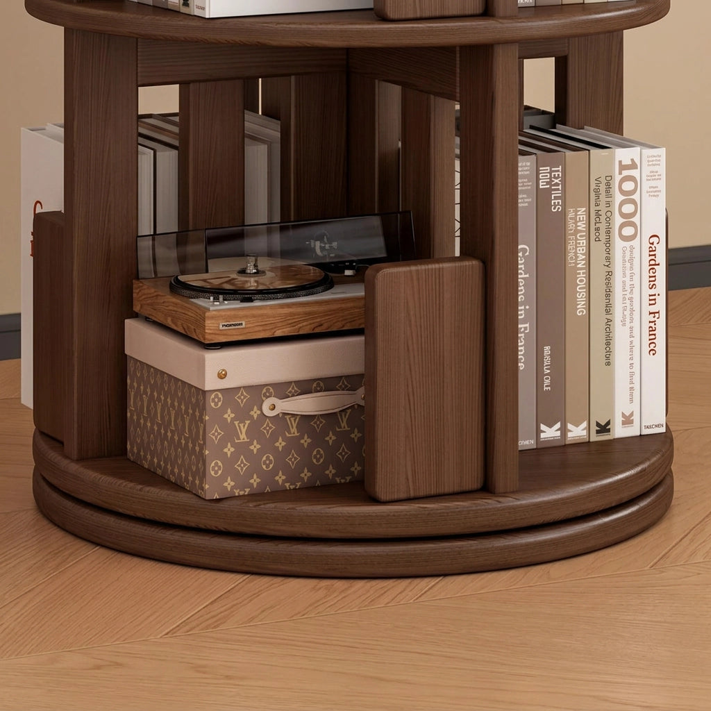 Close-up of the circular rotating swivel base and bottom shelf of a dark wood kids bookshelf with books