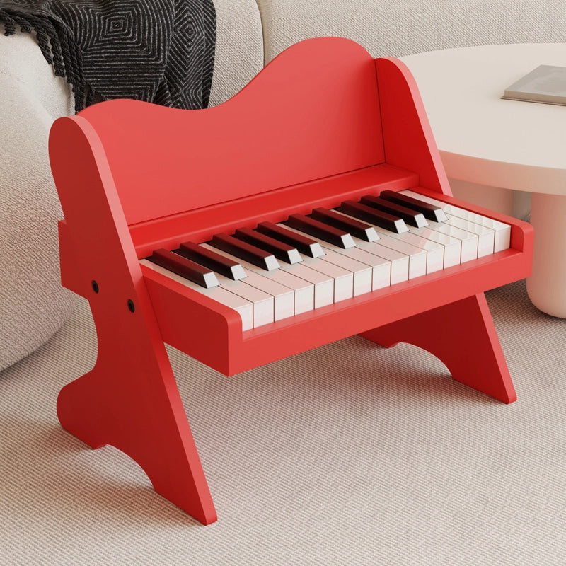 Three-quarter view of a plywood toddler electronic piano with a bright red finish on a rug