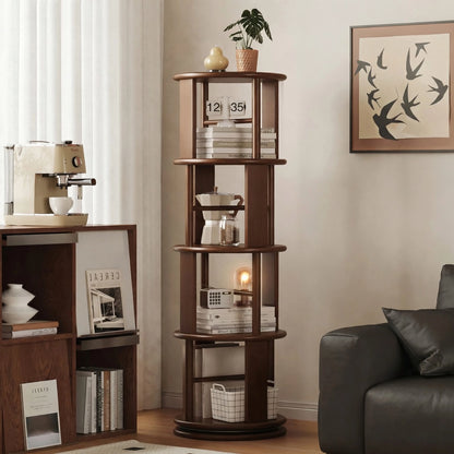 Angled room view of a four-tier solid rubber wood rotating bookshelf filled with books and a moka pot
