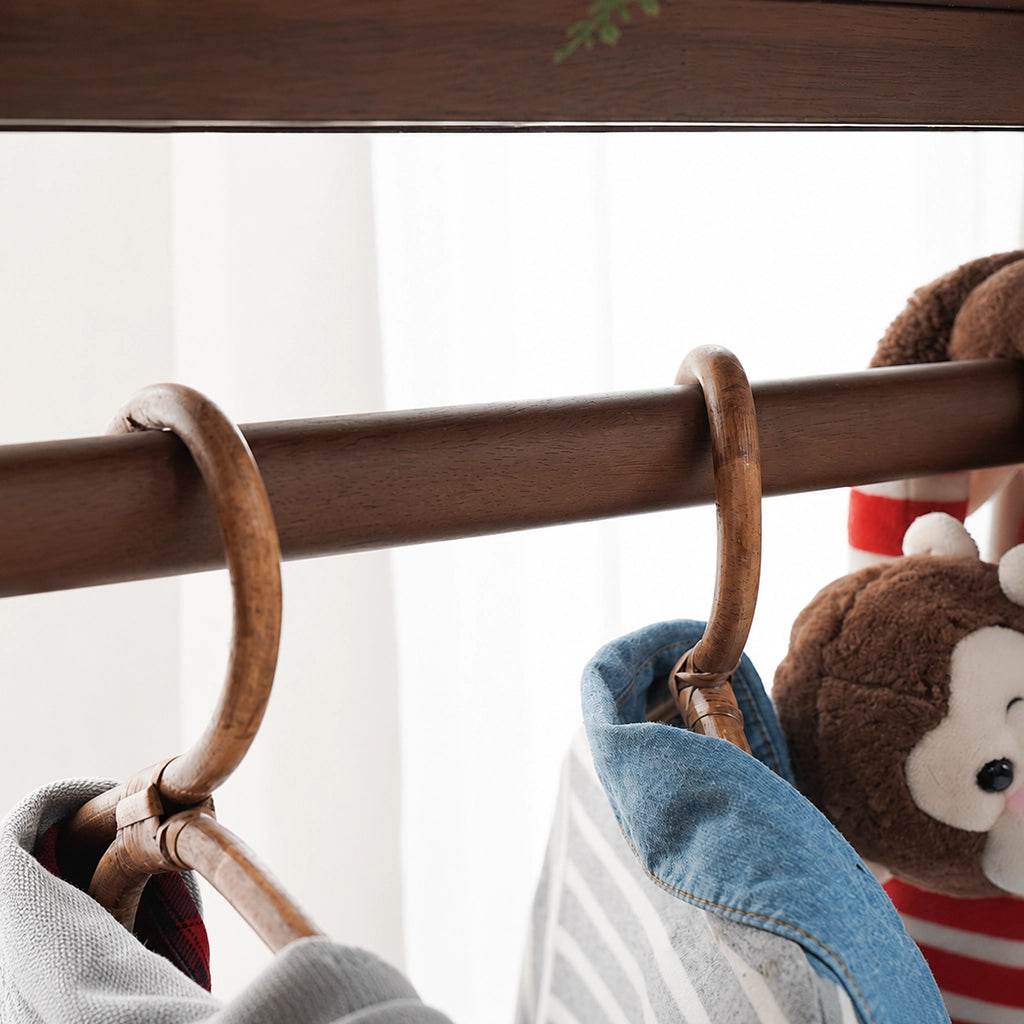 Close-up of a wooden clothes hanger on the dark finish hanging rail of a kids clothing rack