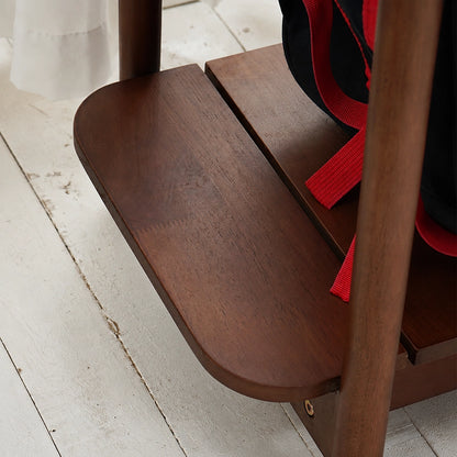 Close-up of the lower storage shelf on a dark wood adjustable kids clothing rack