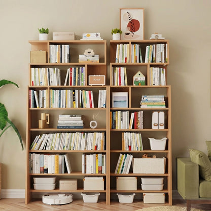 Double ladder bookshelf filled with books and storage bins next to a green sofa in a playroom