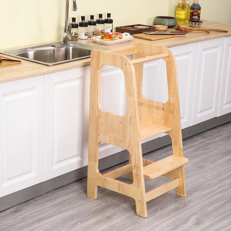 High-angled view of the solid rubberwood toddler standing stool placed against a white kitchen counter