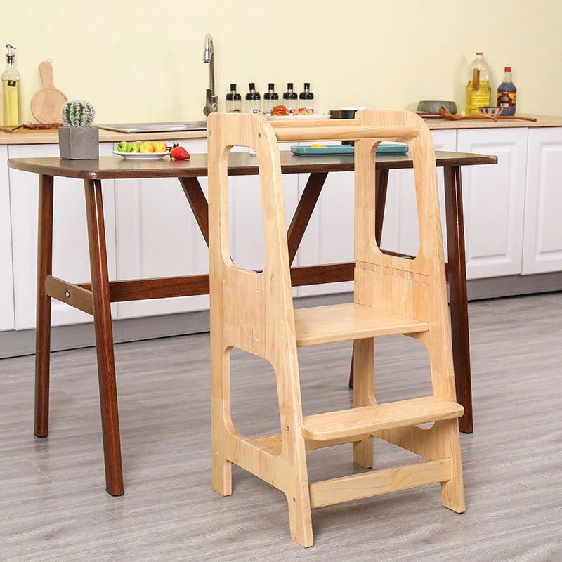 Front-angled view of the solid rubberwood Montessori standing stool next to a wooden dining table
