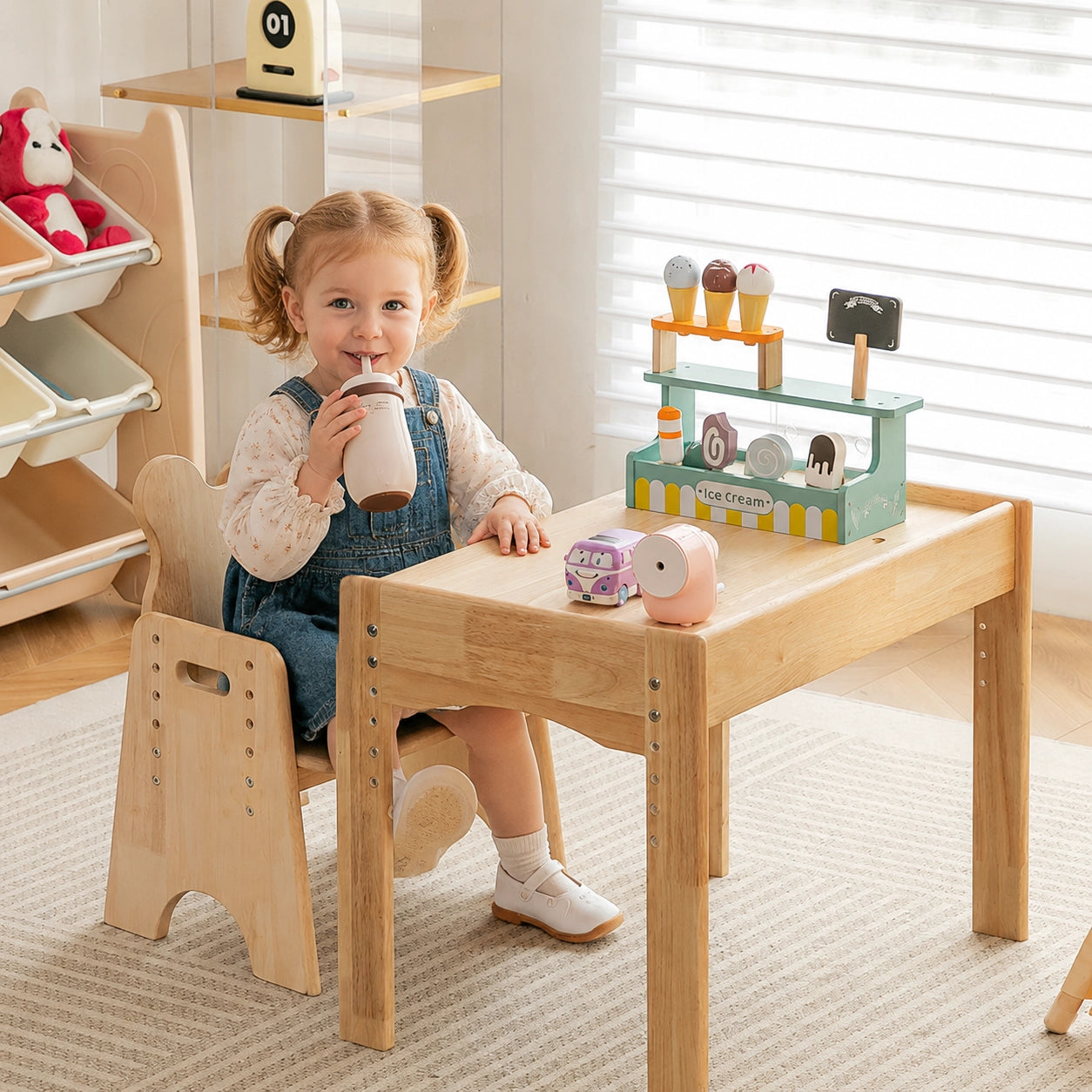 A young girl sitting at an adjustable solid rubber wood toddler desk and chair set while drinking