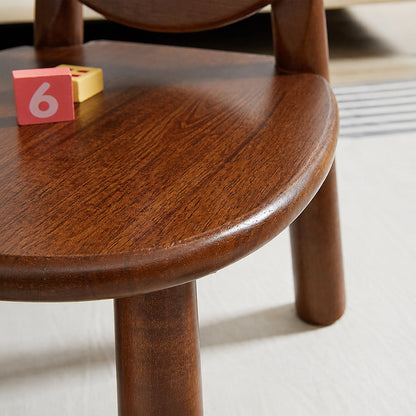 Close-up of the smooth dark wood grain surface and rounded edge of the toddler chair seat