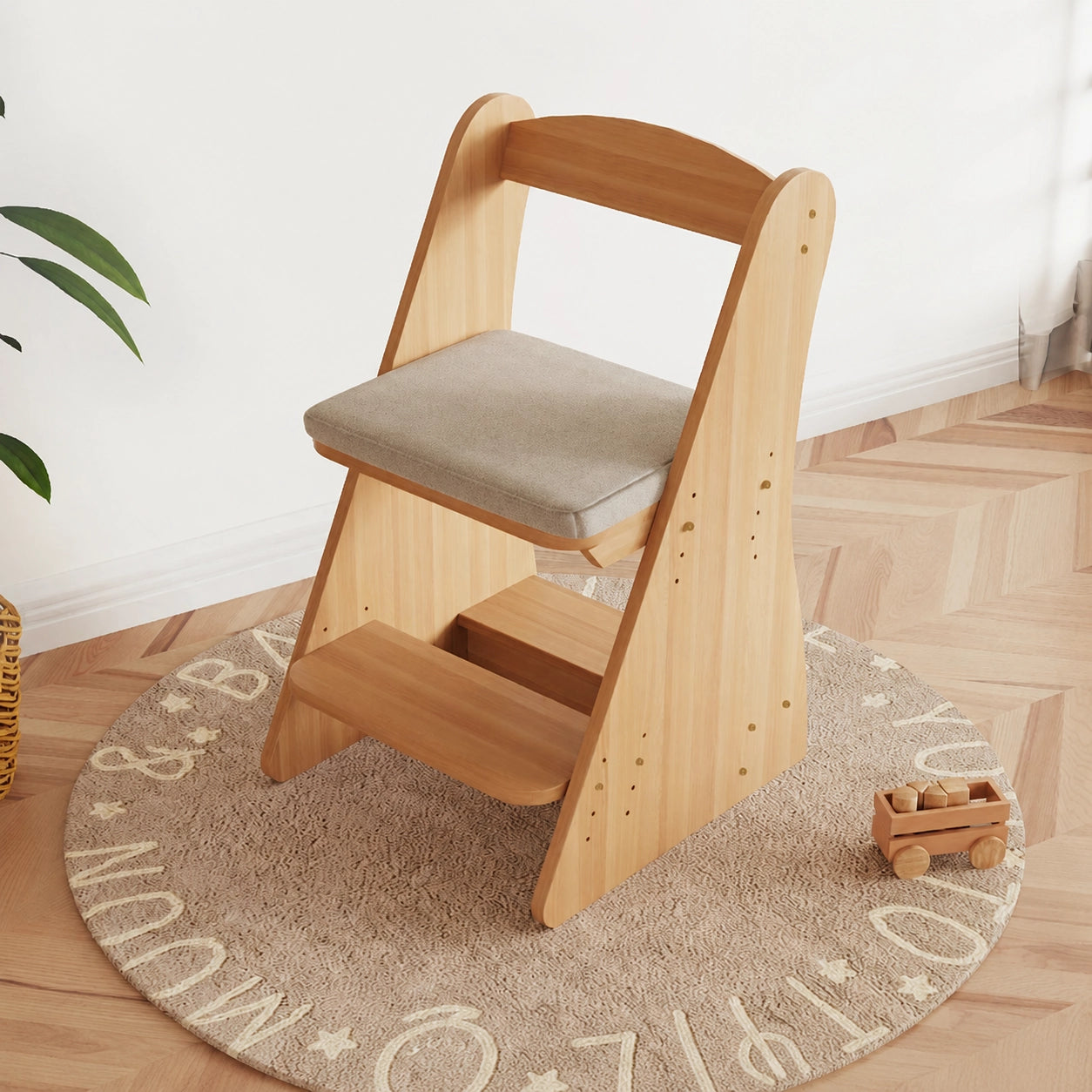 Three-quarter view of the adjustable solid pine chair with a gray cushion seat and built-in footrest