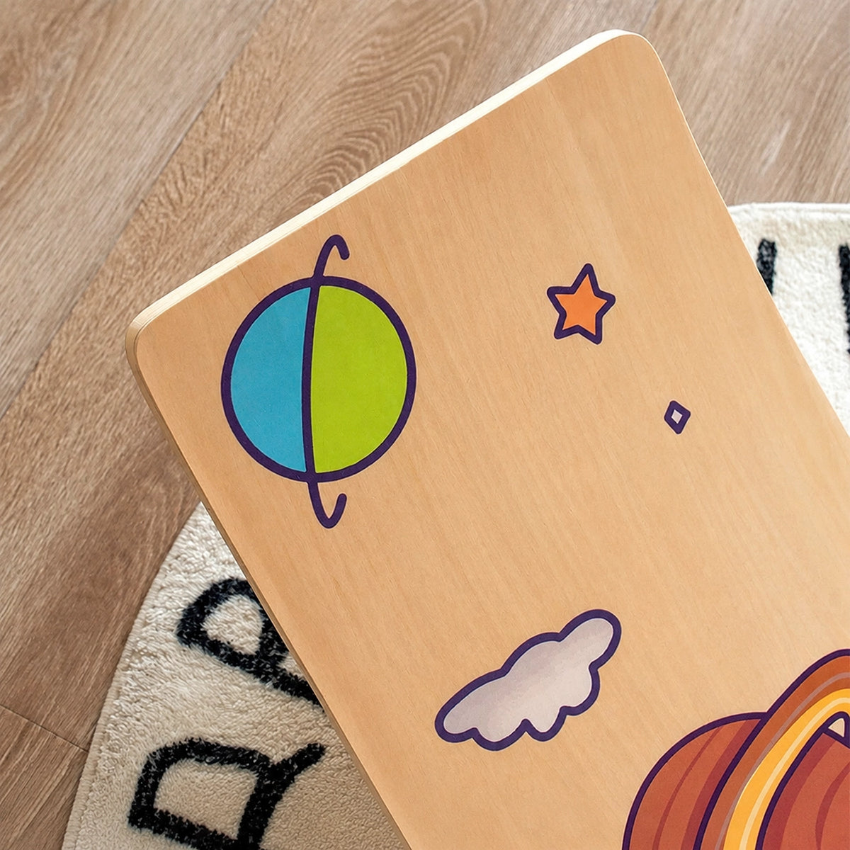 Close-up view of space-themed printed graphics on a smooth multi-layer plywood balance board