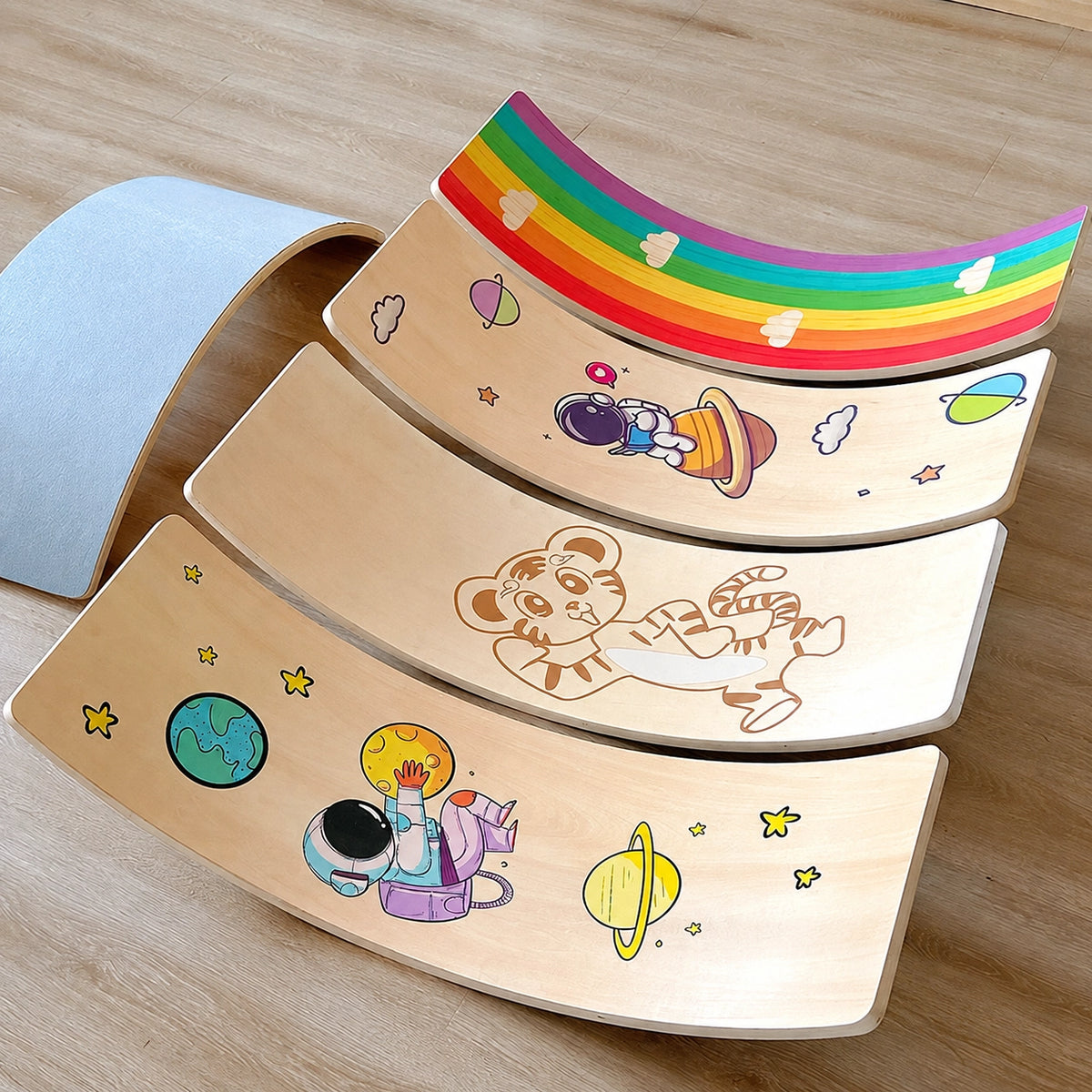 Multiple curved balance boards displayed together showing rainbow, space, and tiger print options