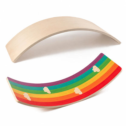 Two curved balance boards on a white background with one plain wood side and one rainbow pattern