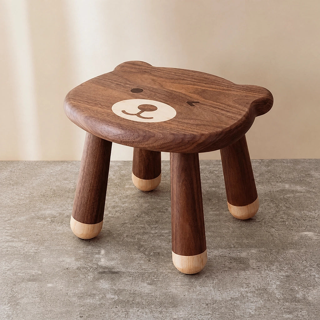 Three-quarter view of a solid black walnut kids stool with a cute bear face design on the seat