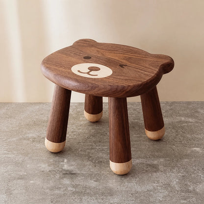 Three-quarter view of a solid black walnut kids stool with a cute bear face design on the seat