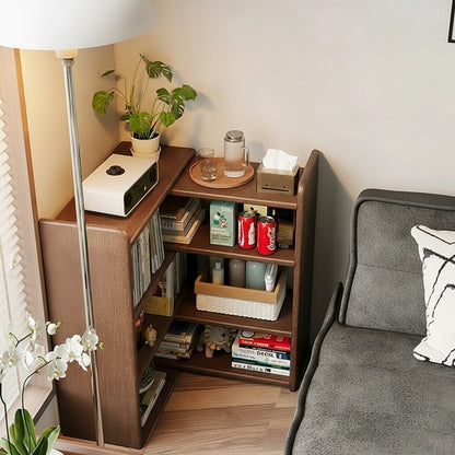 Top-down angled view of an expandable floor bookshelf configured in an L-shape next to a grey sofa