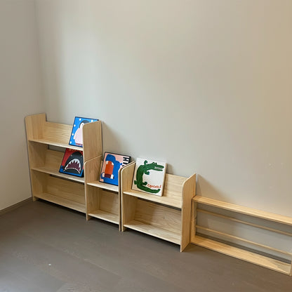 Multiple modular sizes of the floor-standing solid pine bookshelf displayed against a wall