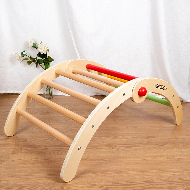 Angled front view of a plywood Montessori toddler climbing arch with natural wood and colored rungs