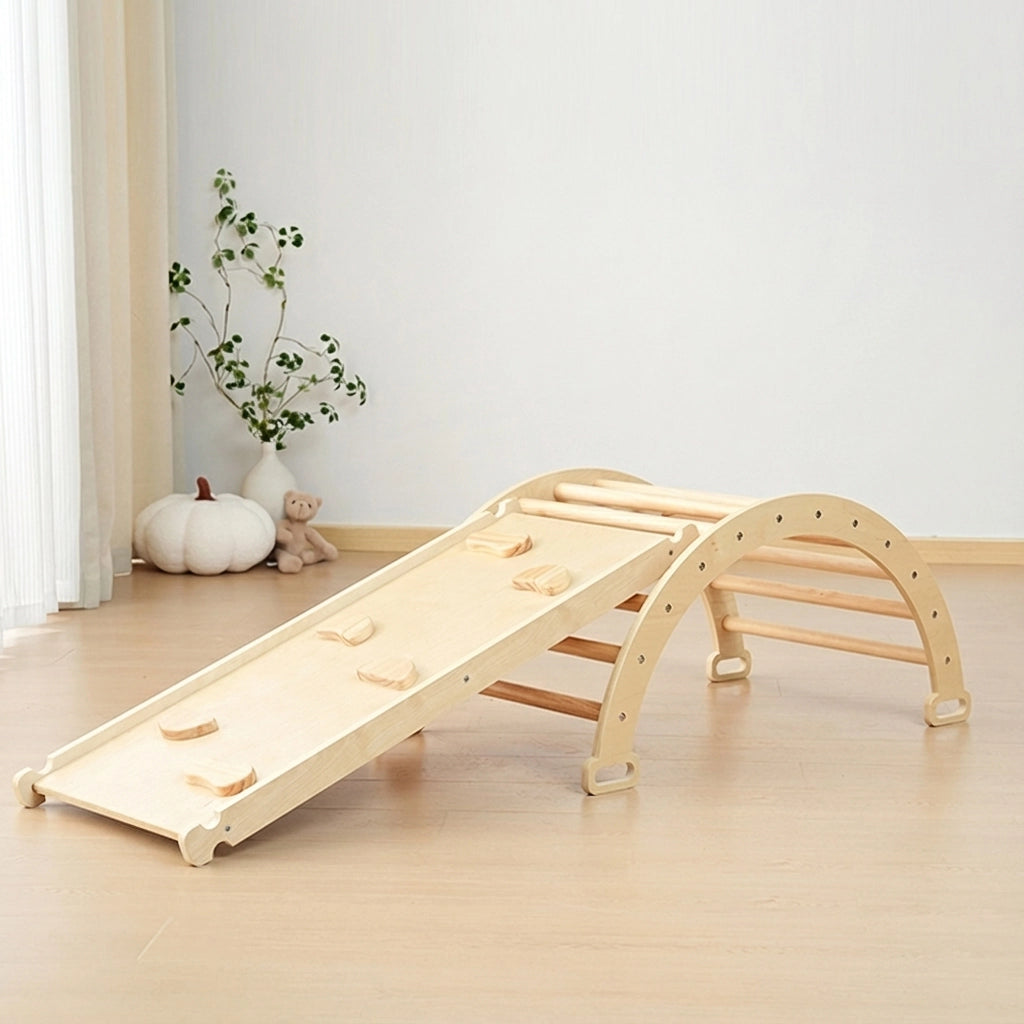 Empty natural plywood climbing arch connected to a wooden rock climbing ramp on a light floor
