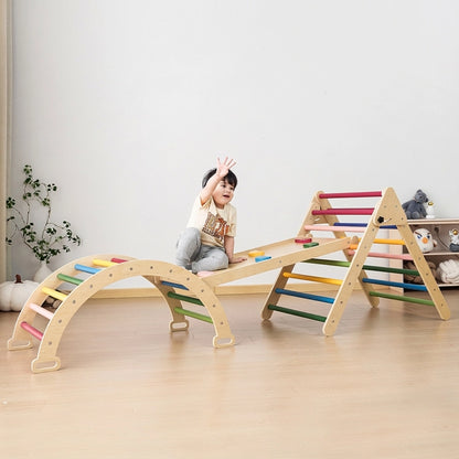 Toddler climbing a colorful rock ramp connected to a rainbow Montessori triangle and climbing arch