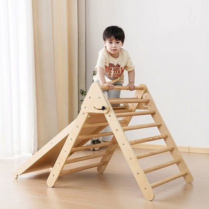 Toddler boy climbing a natural plywood Montessori triangle climber with an attached ramp