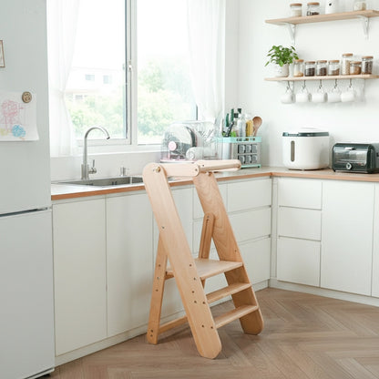 Wide view of a solid beech wood toddler step stool placed in a bright modern kitchen