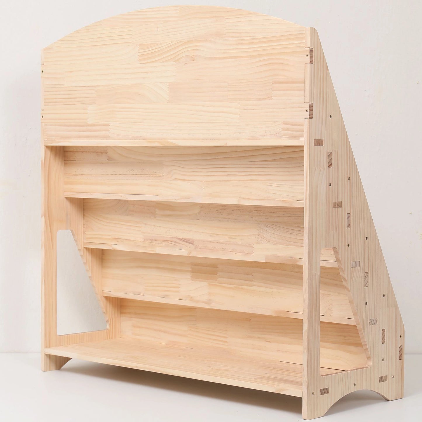 Rear-angled view of an empty solid pine bookshelf showing the open back compartments for extra storage