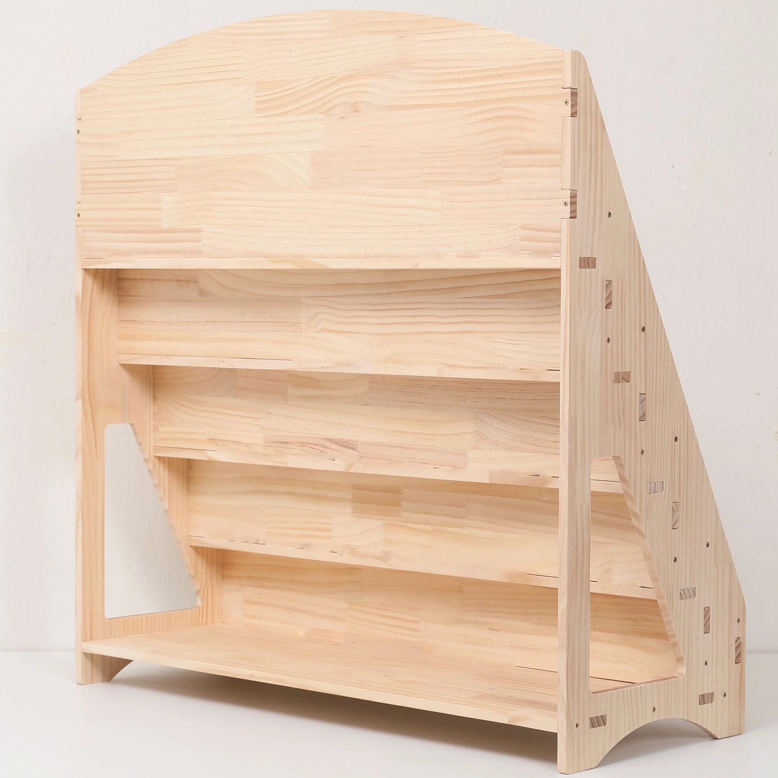 Rear-angled view of an empty solid pine bookshelf showing the open back compartments for extra storage