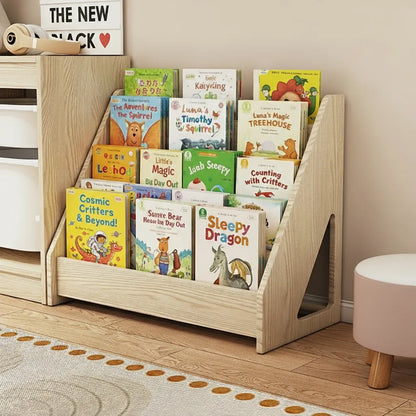 Angled view of a solid pine toddler bookshelf with a triangular side cutout beside a pink stool
