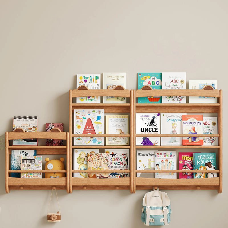 Front view of three front-facing wall bookshelves in different sizes holding colorful children's books