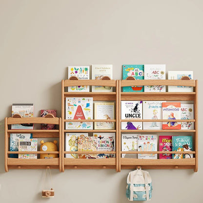 Front view of three front-facing wall bookshelves in different sizes holding colorful children's books