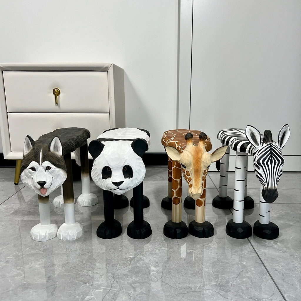 Front view of four hand-carved solid basswood animal low stools including a husky, panda, giraffe, and zebra