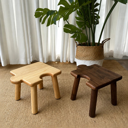 Front-angled view highlighting the unique cutout edges of the light and dark solid wood kids puzzle stools