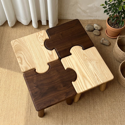 Top view of four solid wood puzzle stools interlocked into a square pattern on a woven rug
