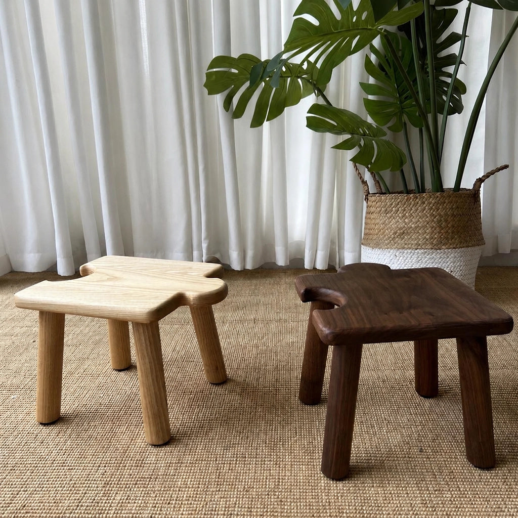 Front view of two interlocking puzzle stools for kids in light and dark solid wood finishes on a woven rug