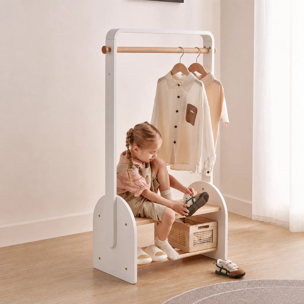 A child sits on the built-in shoe bench of the white kids coat rack to put on their shoes