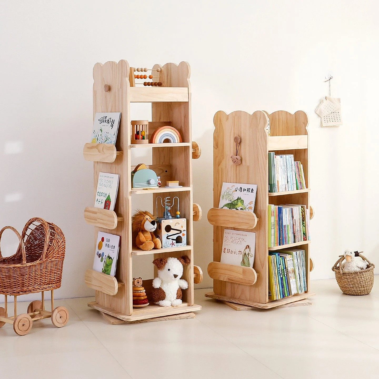 Three-quarter room view of two kids rotating bookshelves in different sizes holding various books and toys