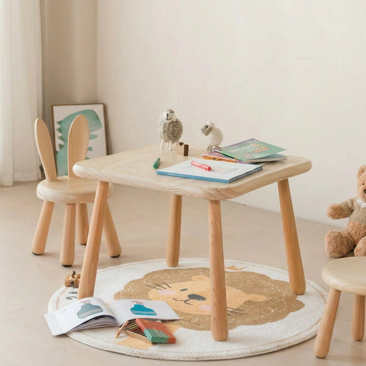 A square solid pine kids table and a bunny-eared chair arranged on a lion-themed rug with children's books