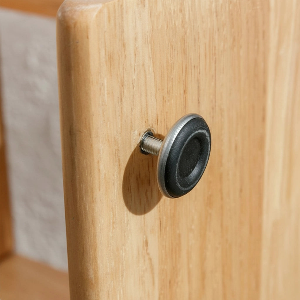 Close-up of a black adjustable leveling foot screw on the side of the wood bookshelf panel