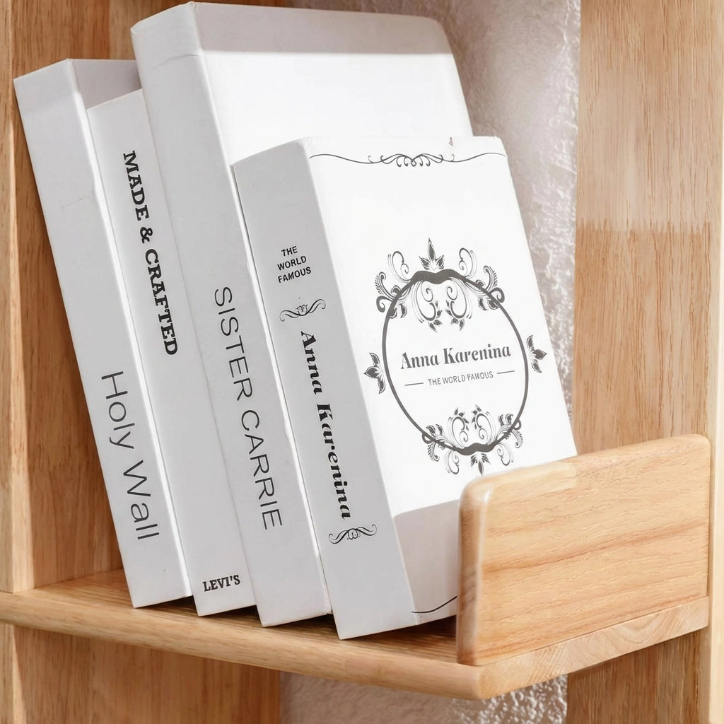 Close-up of four white books displayed on a solid rubberwood shelf tier with a protective lip