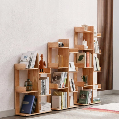 Three kids tree bookshelves in different heights lined up against a white textured wall