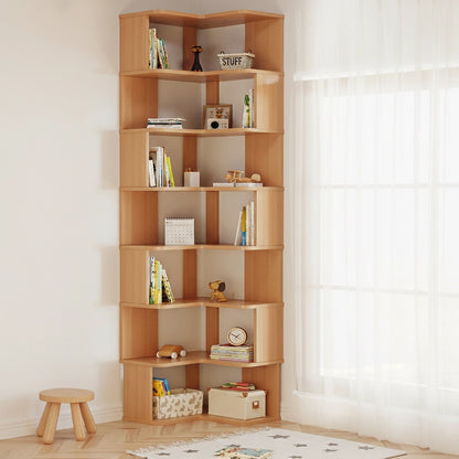 Tall seven-tier L-shaped corner bookshelf in a natural wood finish holding books and toys beside a window