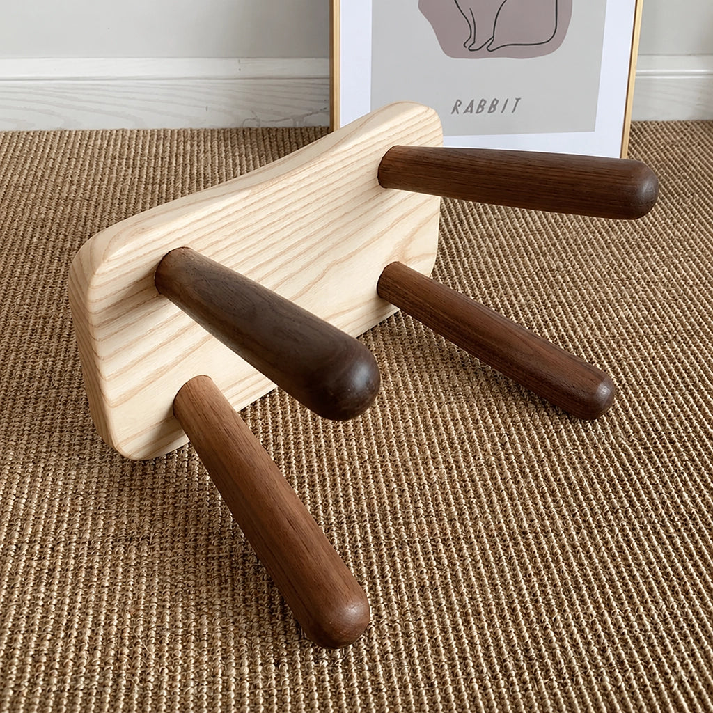 Underside view of a solid wood kids low stool showing the round leg attachments