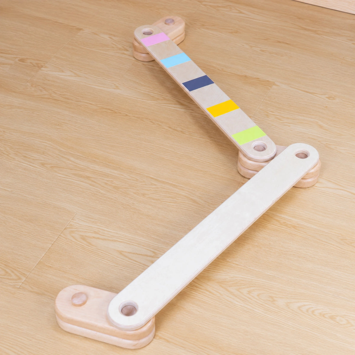 Modular wooden balance beam set arranged in a zigzag layout on a wood floor