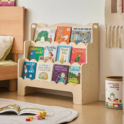 Three-quarter view of a plywood Montessori toddler bookshelf filled with children's books in a room