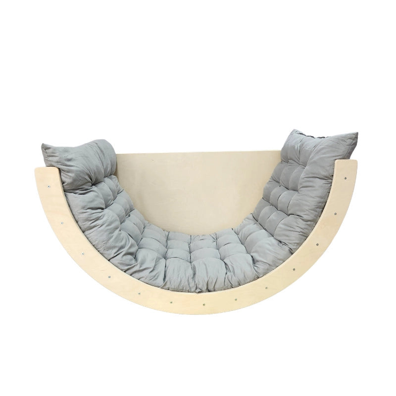 Natural wood Montessori rocker with a tufted grey padded cushion on a white background