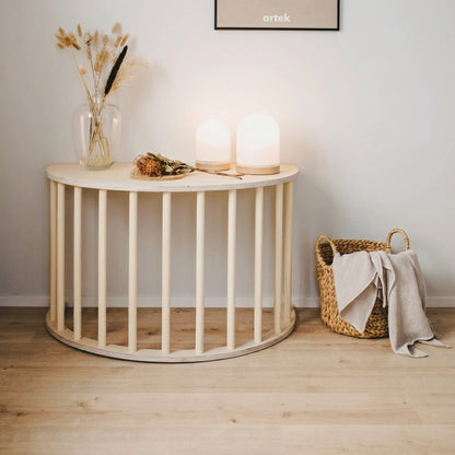 A semi-circular toddler table setup made from the wooden arch structure with two glowing dome lamps on top