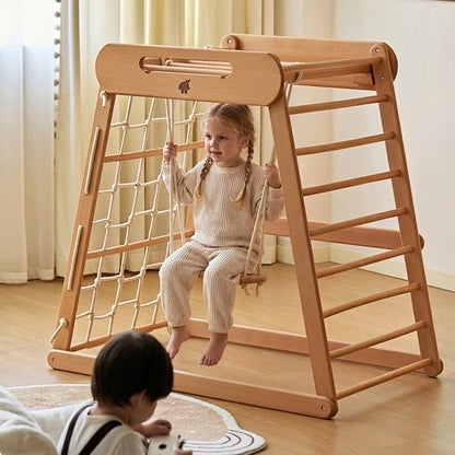 Toddler girl playing on a wooden rope swing attached to the beechwood climbing gym frame