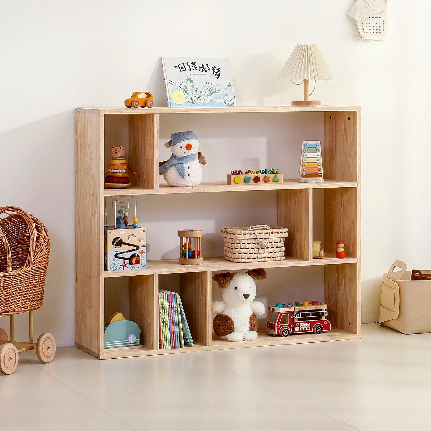 Angled view of a single solid pine toddler cubby organizer with asymmetric shelves holding books and toys