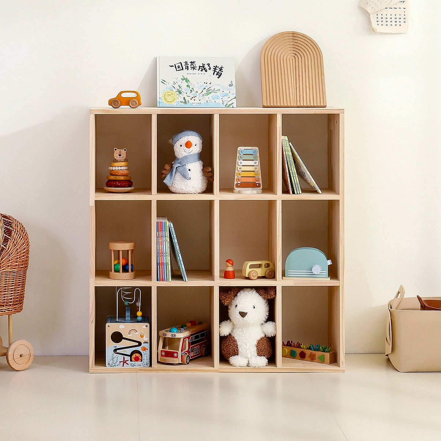 Front view of a three-tier twelve-cube solid pine Montessori organizer holding colorful toys and children's books