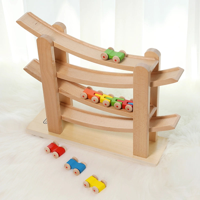 High-angle view of a solid beech wooden car ramp toy with colorful miniature cars on a soft white rug
