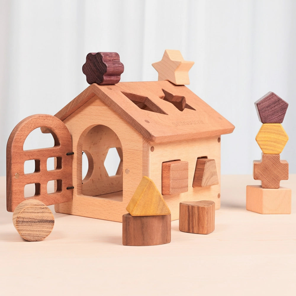 Wooden shape sorter house showing an open door beside a vertical stack of solid hardwood geometric blocks