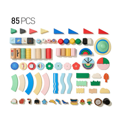 Flat lay of an 85-piece solid beech wood building blocks set with varied shapes and patterns on a white background